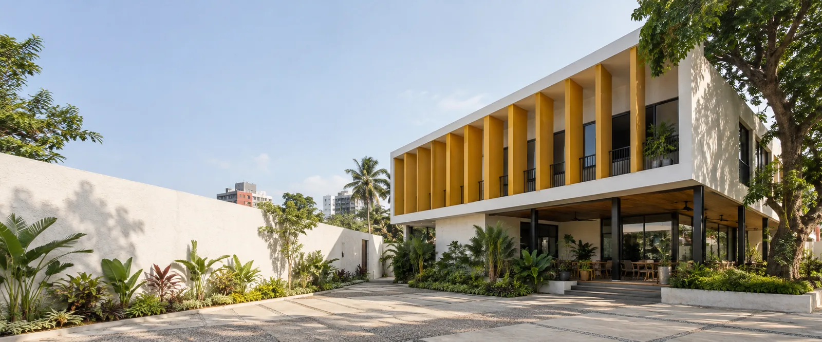 A white building with yellow fins shading its upper floor